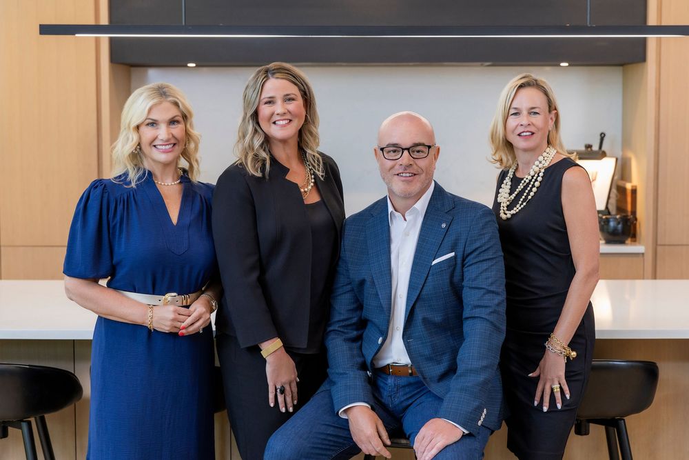 Professional group photo of business team members smiling together in modern office setting.