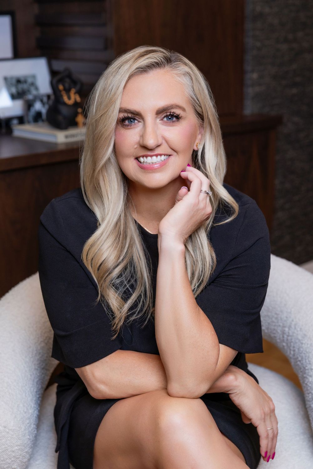 Professional portrait series showing a person in a black outfit posing on a white couch in an indoor setting.