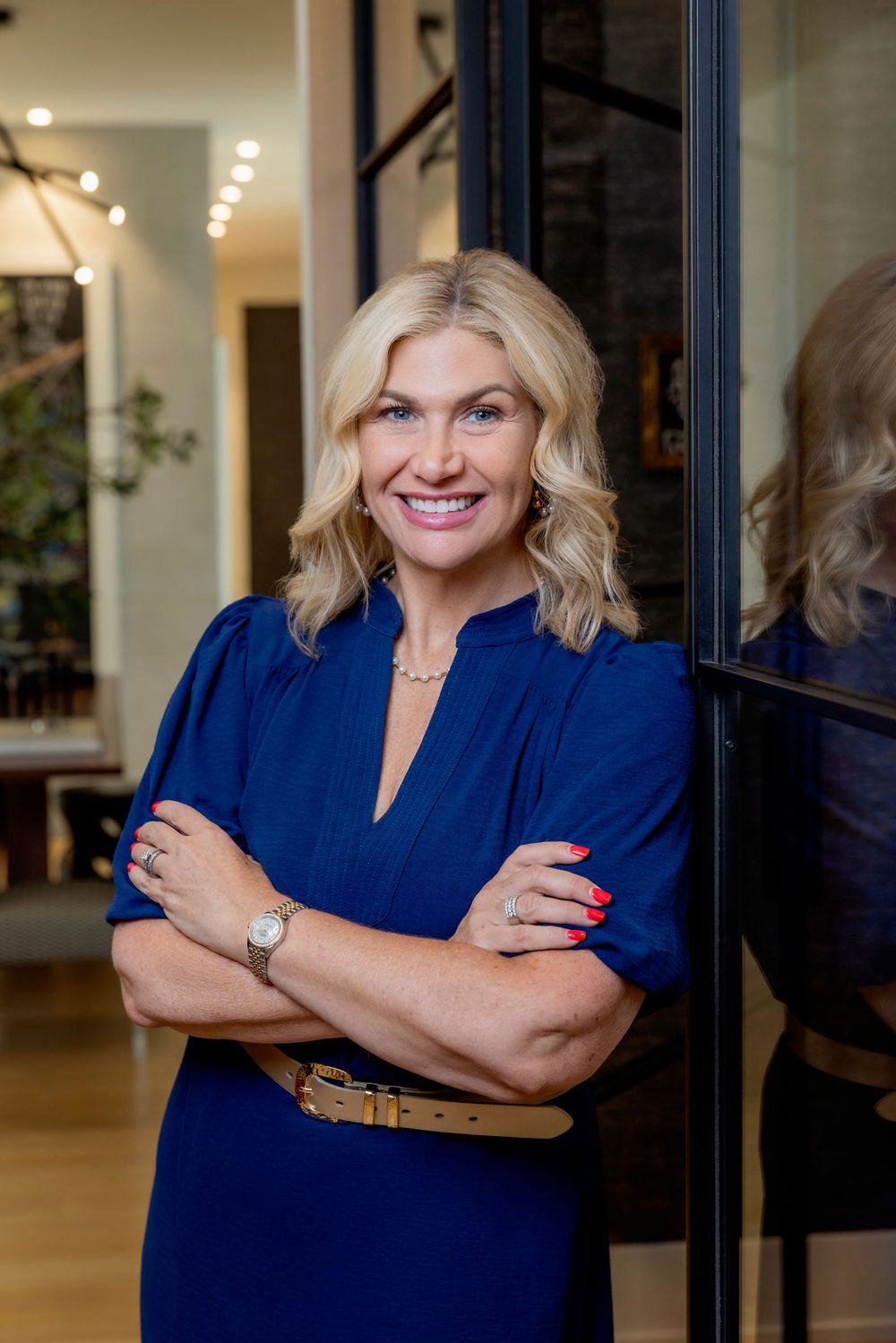 Professional portrait series showing a person in a navy blouse posing against an office interior background.