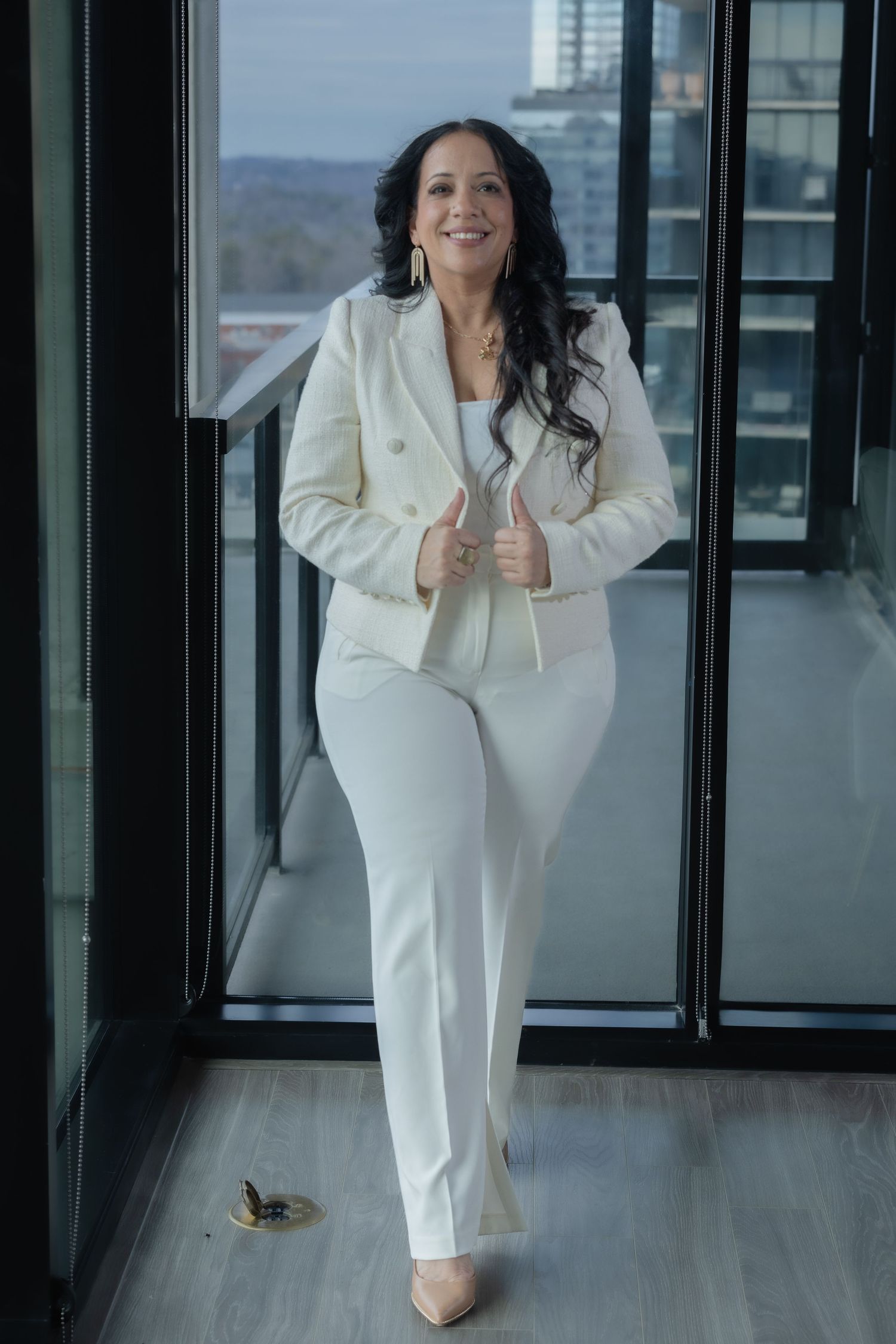 Professional business portrait session in modern office space with glass windows.