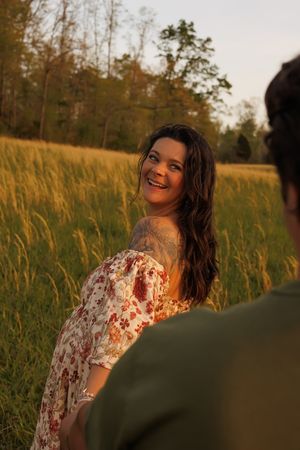 Romantic golden hour photoshoot in a tall grass meadow with a flowing floral dress.