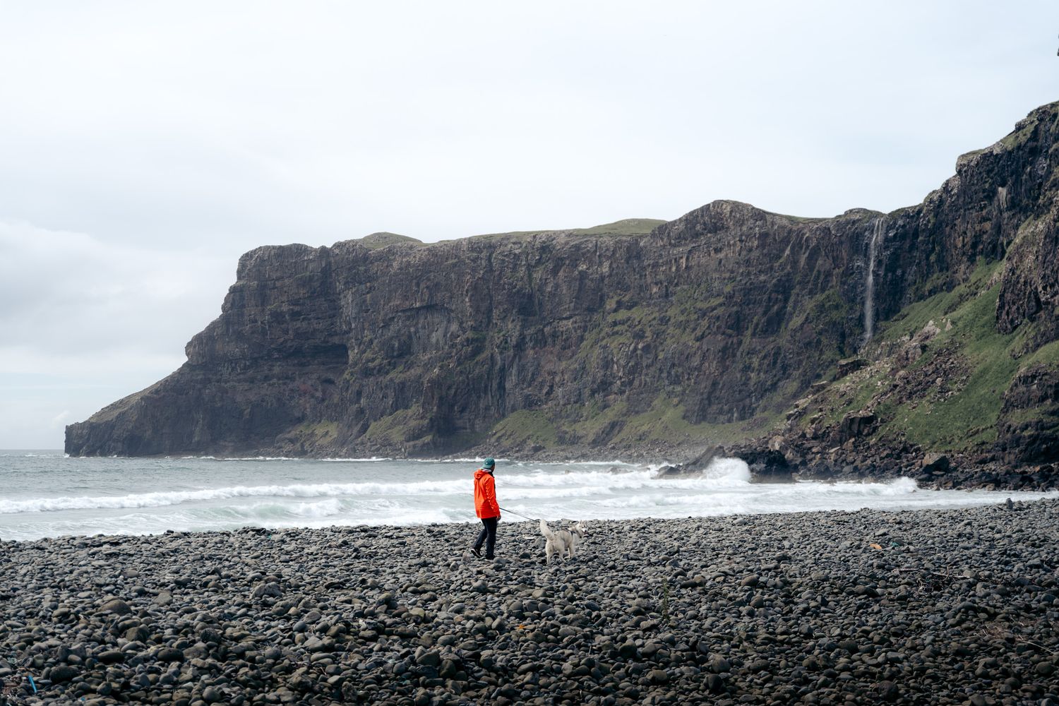 randonneur avec son chien sur la plage de talisker sur l'ile de skye en ecosse