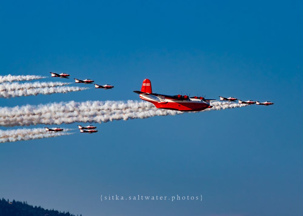 Hawaii Mars and CF Snowbirds with smoke trails against mountain scenery.