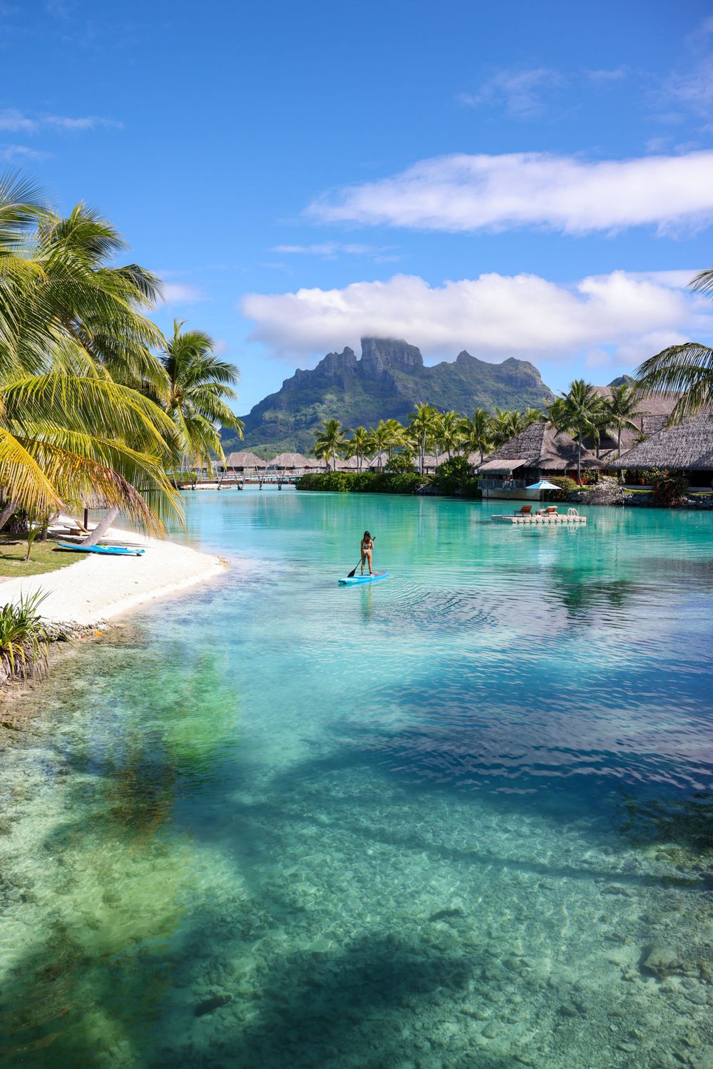 Tropical paradise in Bora Bora with overwater bungalows and Mount Otemanu in background.