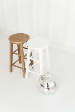 Image sequence shows a wooden stool gradually fading out while a disco ball becomes more visible against white background.