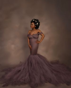 Pregnant woman in beautiful gown posing in maternity photoshoot