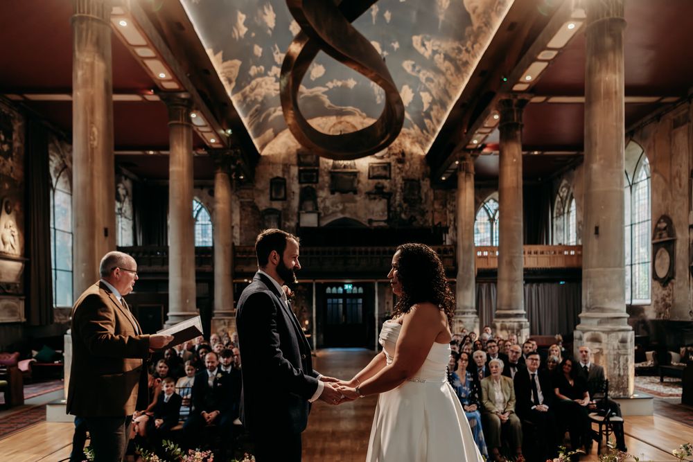 Elegant wedding ceremony in a rustic industrial venue with exposed brick walls and romantic lighting.