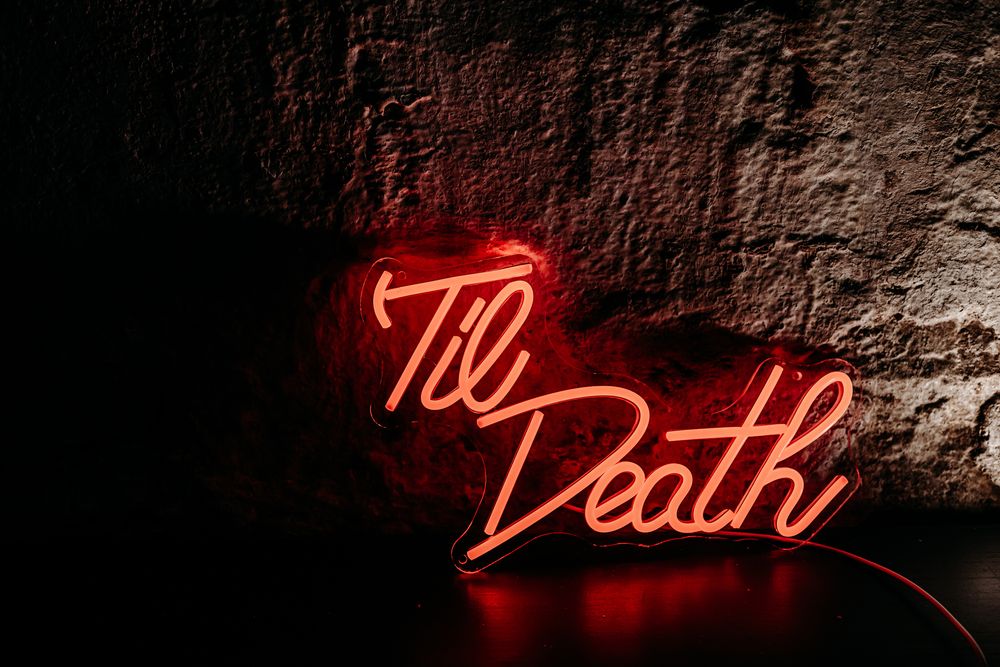 Red neon text signs glowing against dark textured walls create a moody atmospheric display.