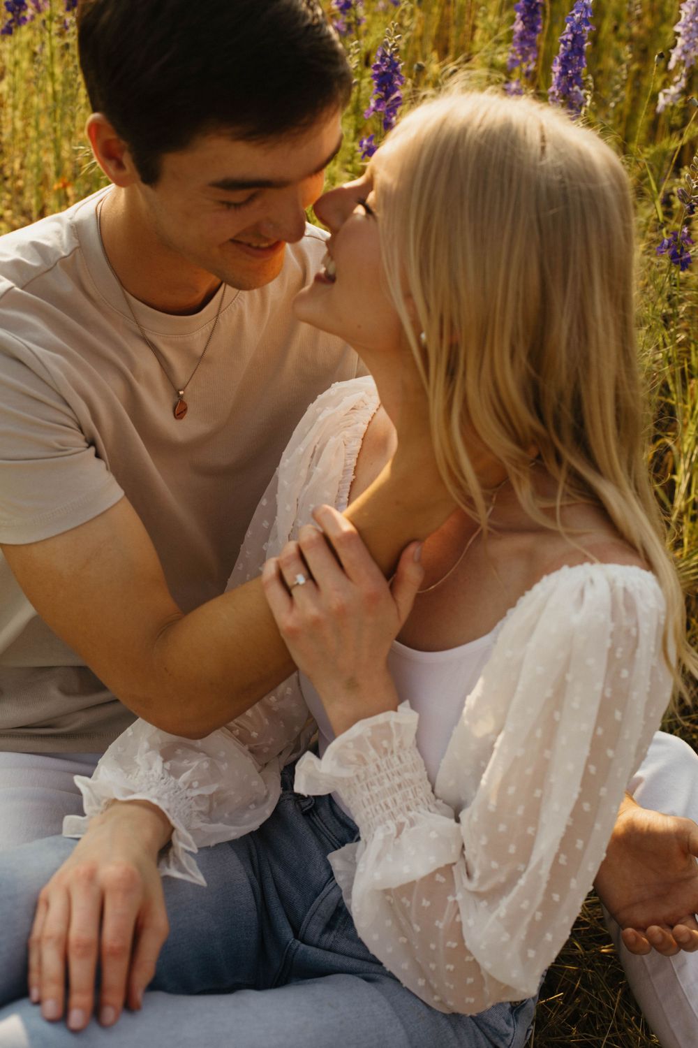 Romantic couple sharing tender moments in a blooming wildflower field.