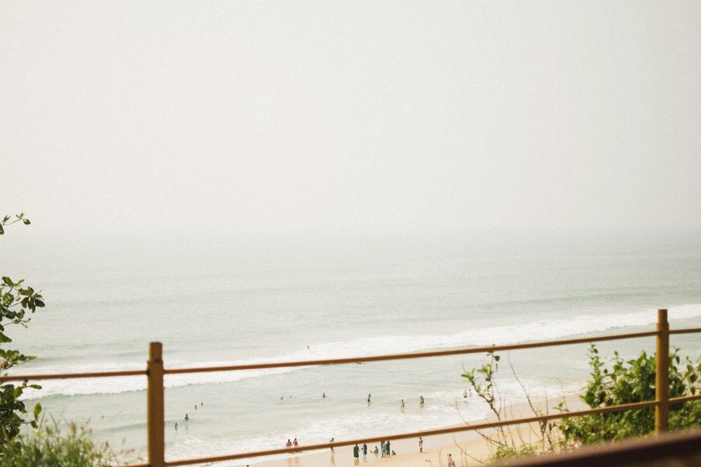 Misty coastal view with wooden railing overlooking a beach and ocean.
