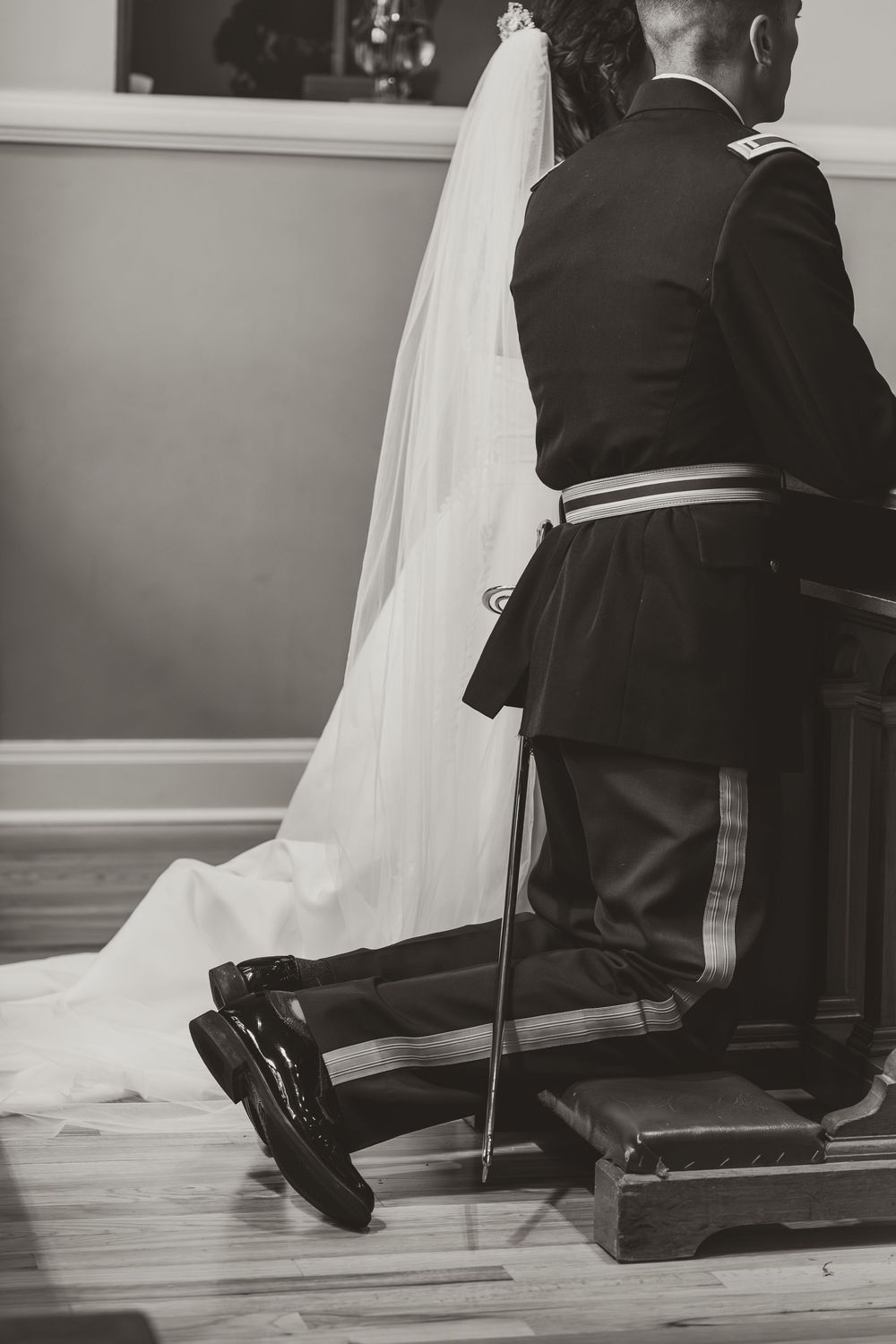 Black and white image showing formal attire and flowing wedding dress train.