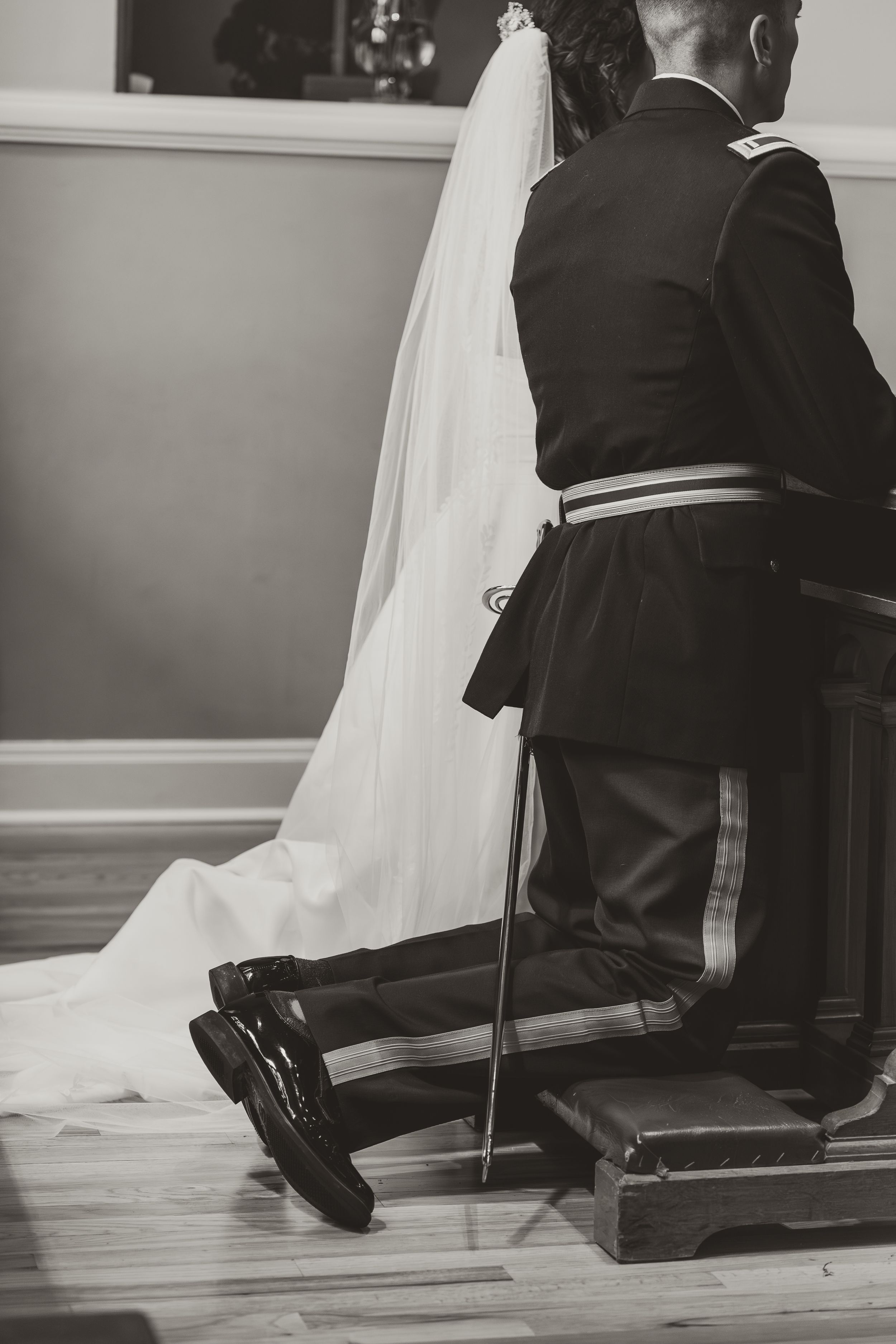Black and white image showing formal attire and flowing wedding dress train.
