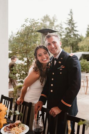 Wedding couple shares joyful moment while sitting at reception table.