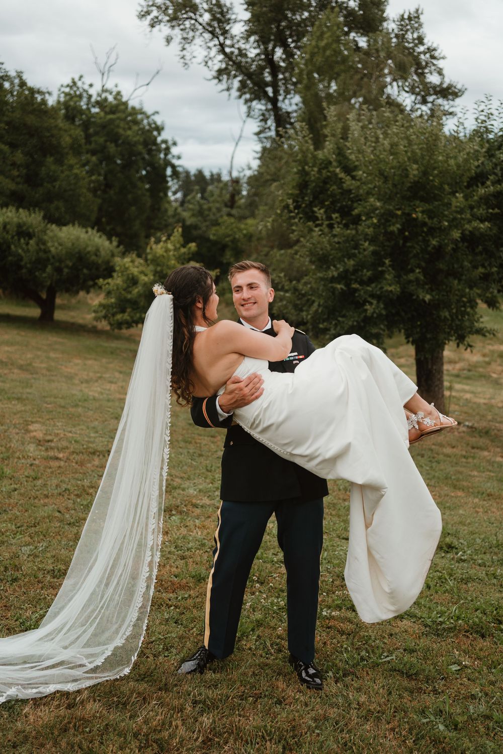Groom dramatically dips bride during romantic outdoor wedding photos.