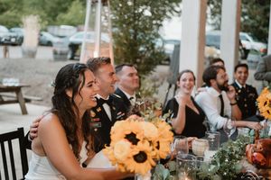 Wedding reception table decorated with sunflowers and greenery.