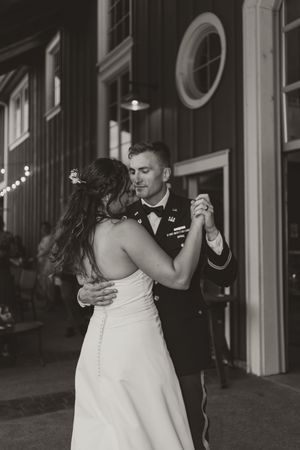 Black and white photo of couple dancing at wedding reception venue.
