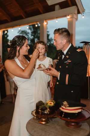 Wedding couple shares cake feeding moments during their reception celebration.
