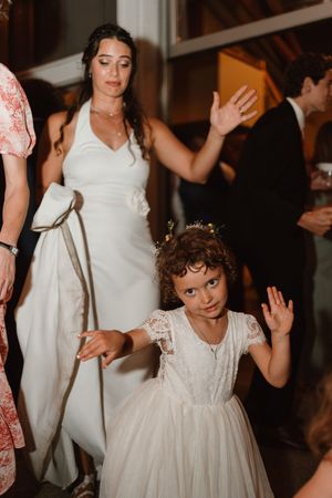 Young children in formal attire dancing at a wedding reception.