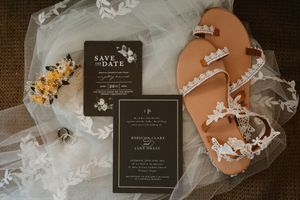 Wedding invitation suite with black cards and floral details on dark background.