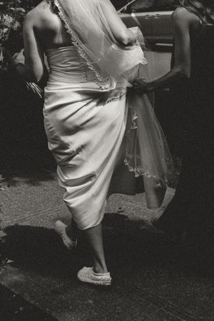 Black and white photo of bride's dress and shoes during dance.