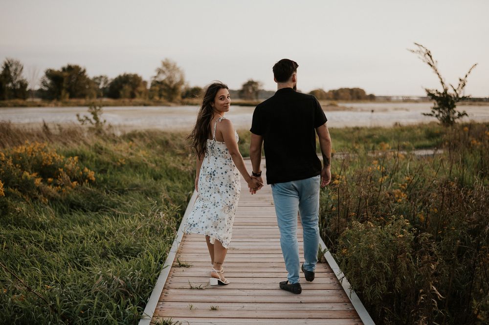 Photo de couple en extérieur sur un quai en bois, paysage naturel et lumière douce