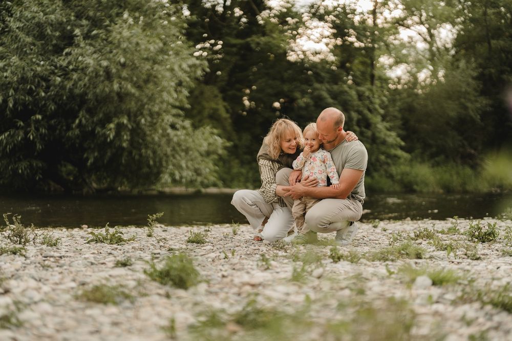 Liebevolle Eltern spielen mit Kleinkind am Wasser bei einem Fotoshooting in Munderkingen. Fotografiert von Ramona Maier