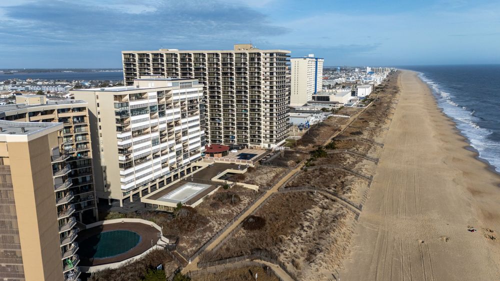 Aerial view of oceanfront condominiums and hotels along a wide sandy beach on the Atlantic coast.