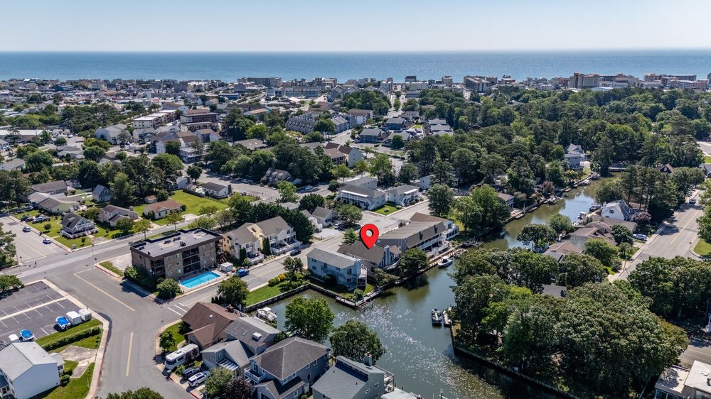 Aerial view of  coastal residential neighborhood with waterfront homes and boats along a canal in Delaware .
