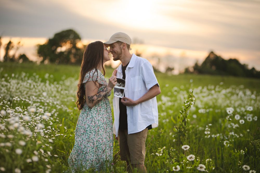 Couple sharing intimate moment in wildflower field at sunset.