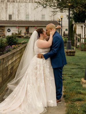 A romantic wedding couple sharing intimate moments in a garden setting, showcasing the bride's flowing white gown and veil.