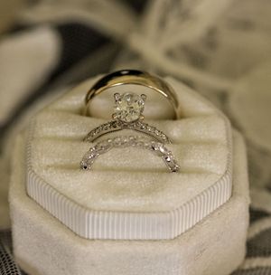 Close-up sequence of a diamond engagement ring being placed on a white cushioned ring box display.