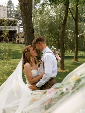 A romantic outdoor wedding photoshoot sequence showing a couple embracing under large trees with flowing veil details.