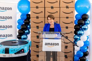 Amazon corporate event with blue and black balloon decorations and branded backdrop.