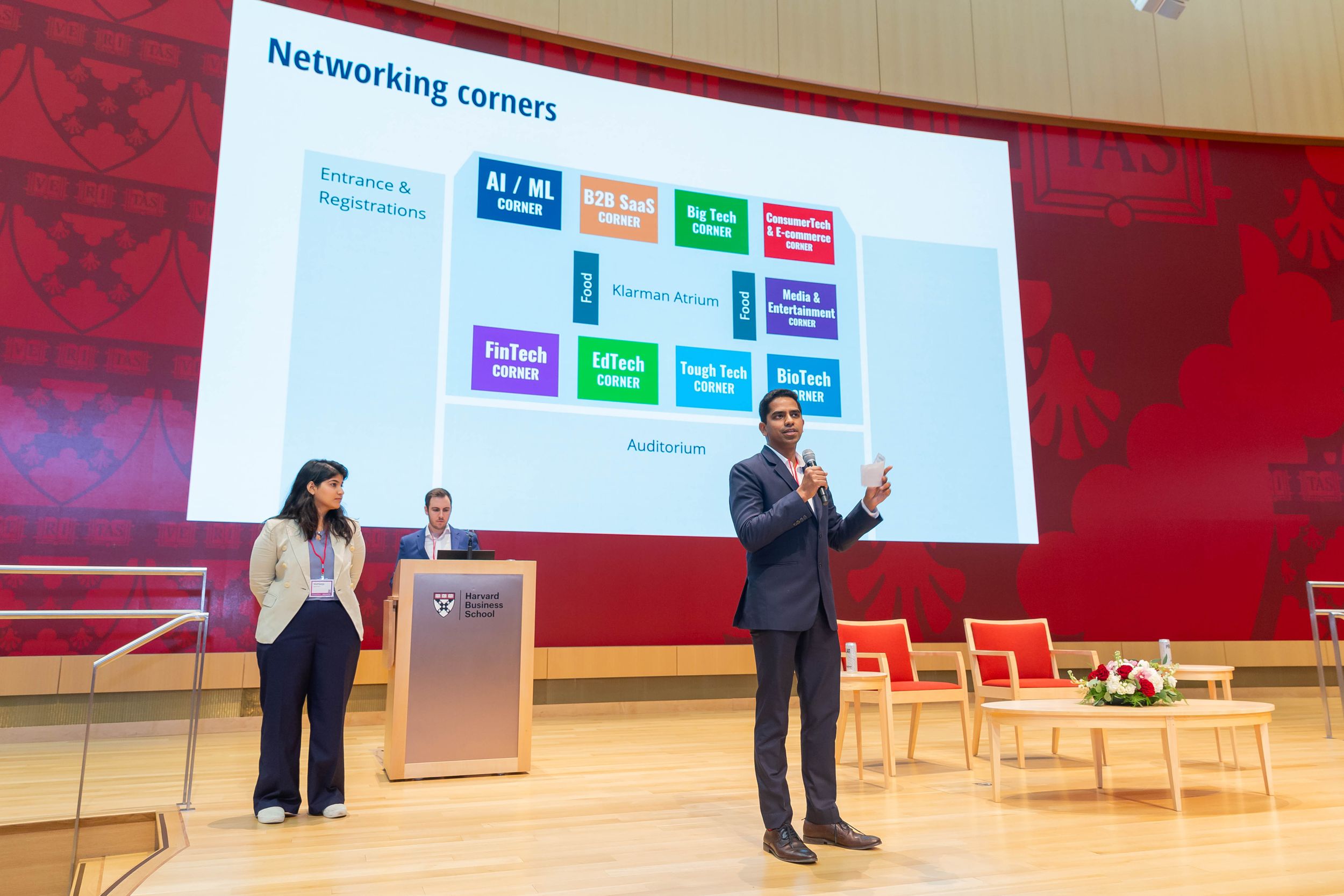 Presenters discussing networking concepts with slide display at tech conference.