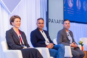 Professional panel discussion with three speakers on stage at conference.