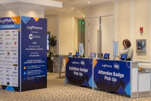 Conference registration area with LogiPharma branding and check-in desk.