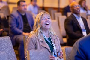 Conference attendee enjoying presentation in audience seating.