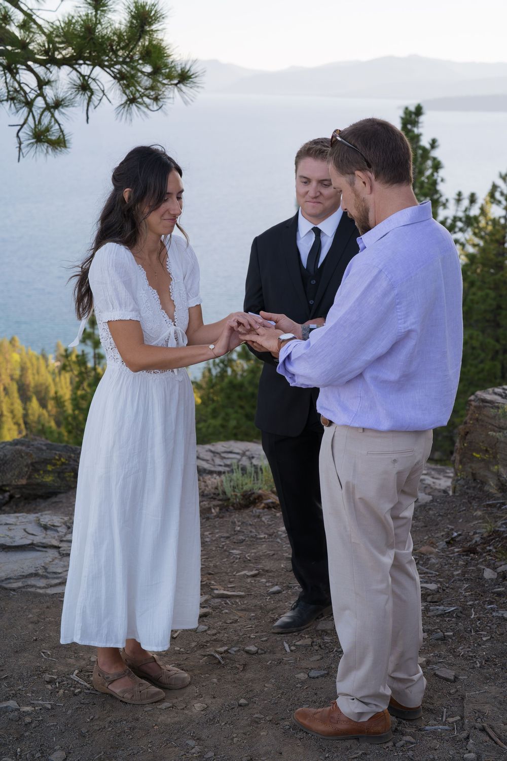 A couple exchanges rings during an intimate outdoor mountain wedding ceremony with a scenic vista backdrop.