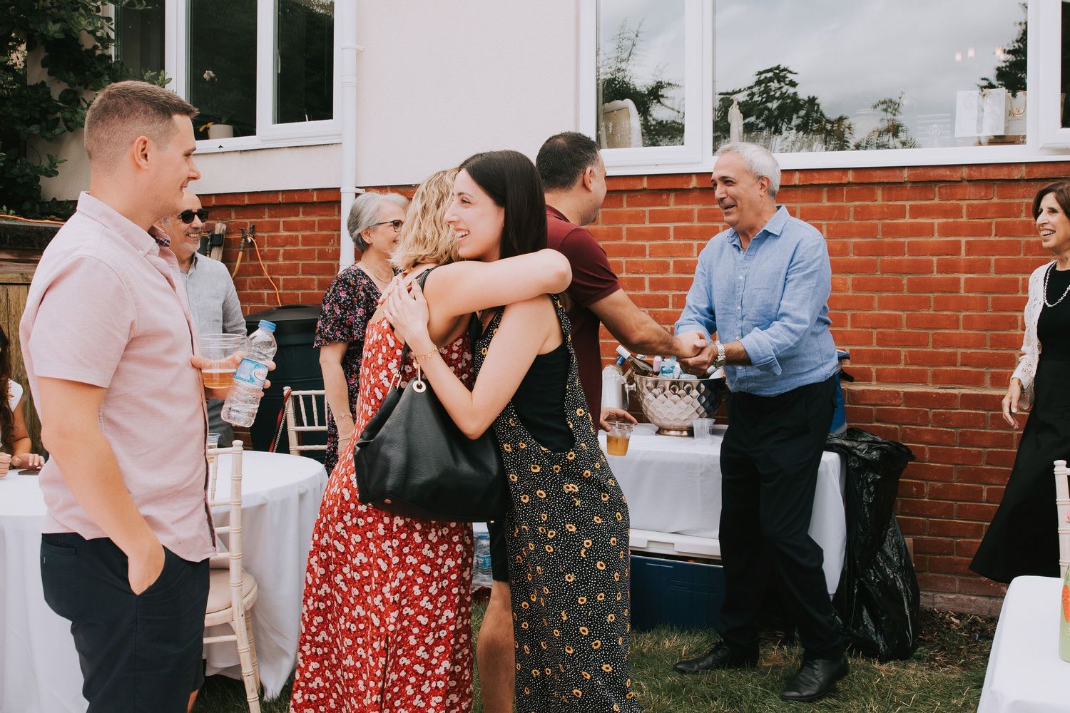 Guests hugging each other at an outdoor birthday event enjoying the party vibes