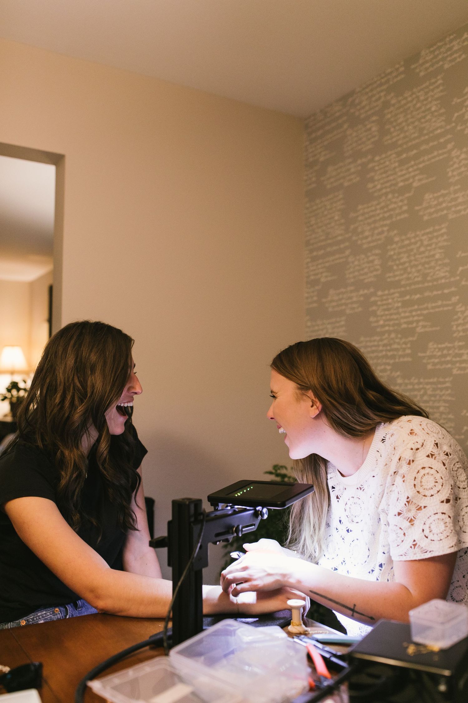 Two friends sharing conversation and laughter at table indoors.