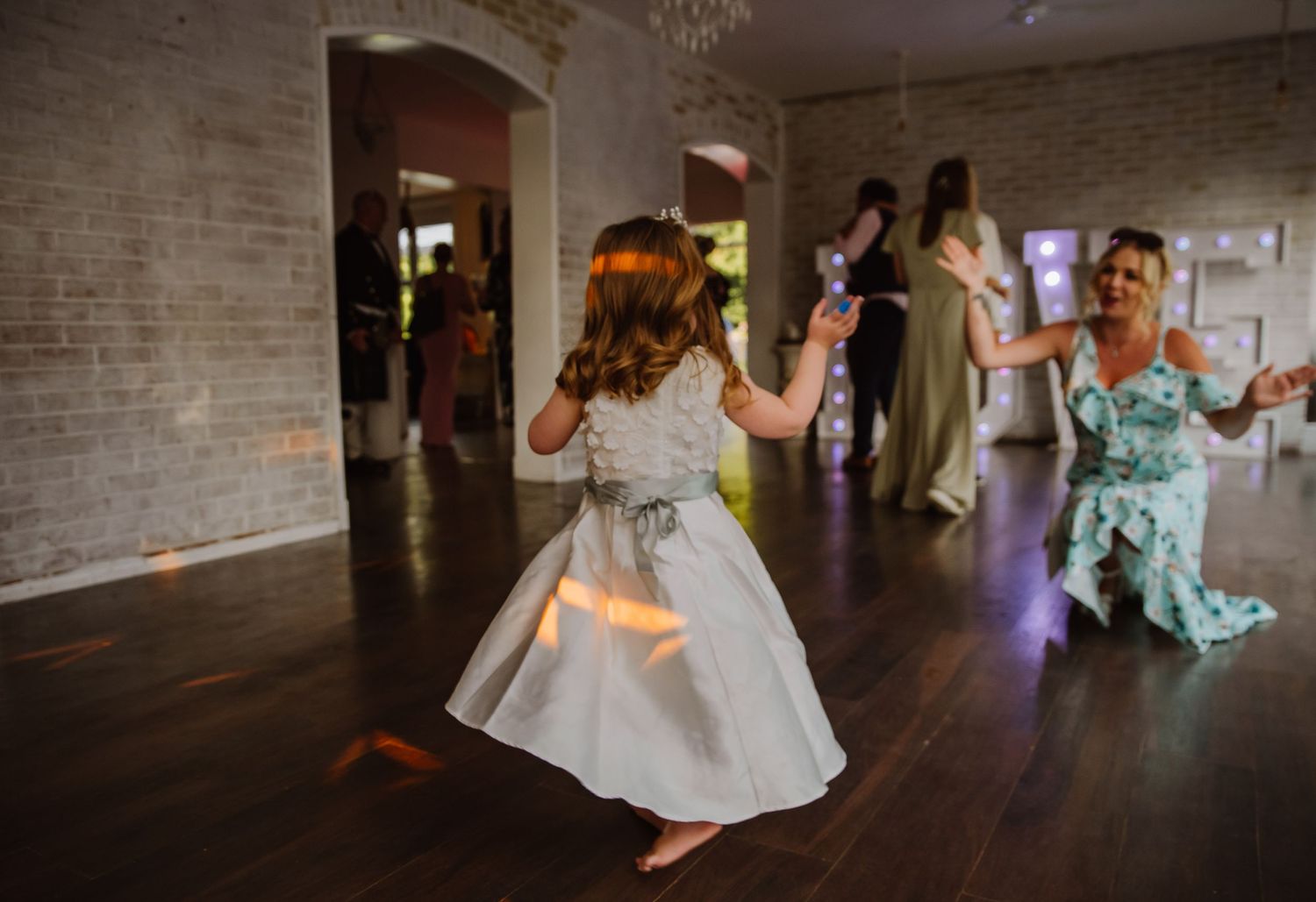 A young bridesmaid is dancing at the wedding party help at the Grey Manor Hotel, Wiltshire near Andover, Cholderton, Salisbury. A love light