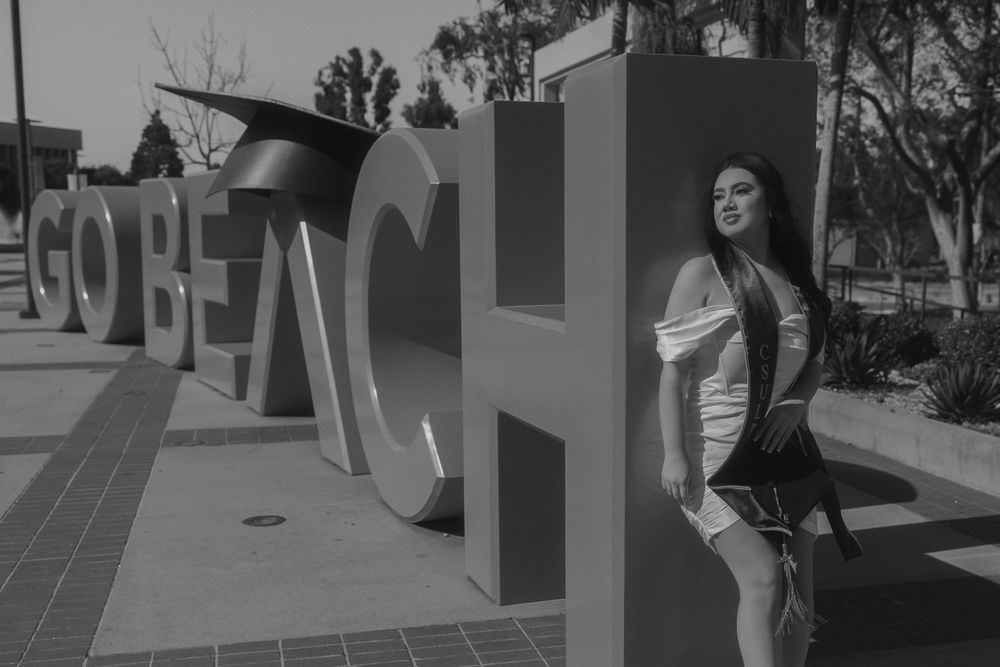 Black and white photo by architectural lettering outdoors.