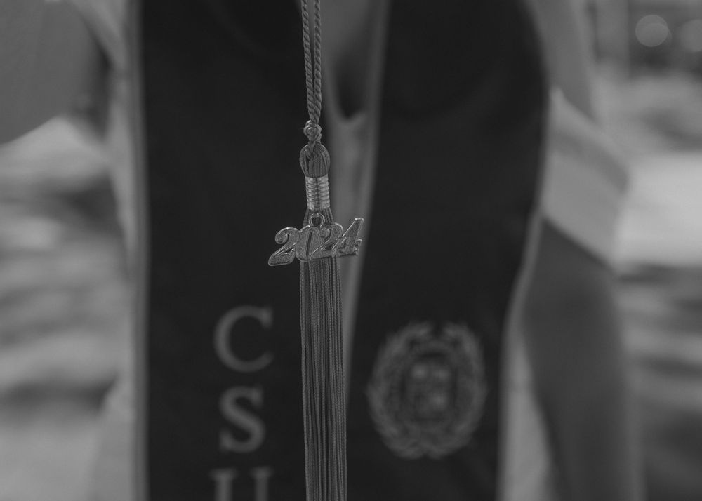 Close-up of graduation tassel against academic regalia.