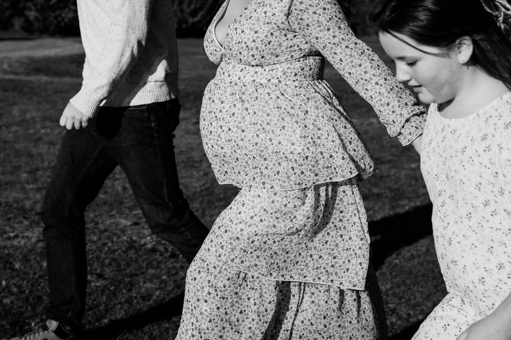 mid shot of Pregnant couple walking with child