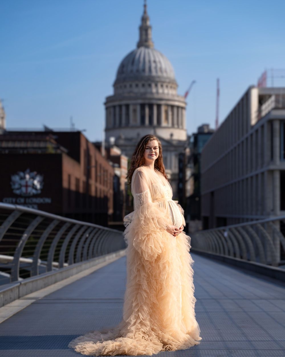 A maternity photo shoot with St Paul's Cathedral dome in the background on London's Millennium Bridge.