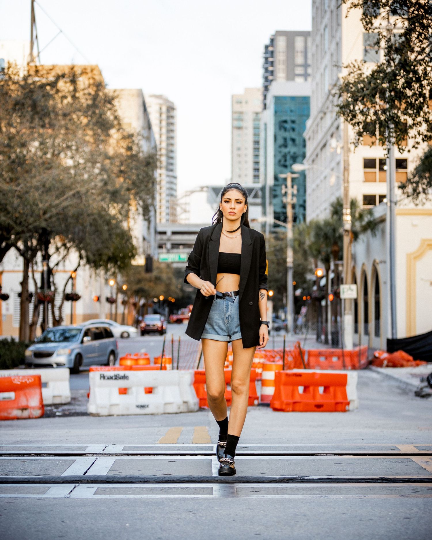 Urban street scene with construction barriers and high-rise buildings in background.