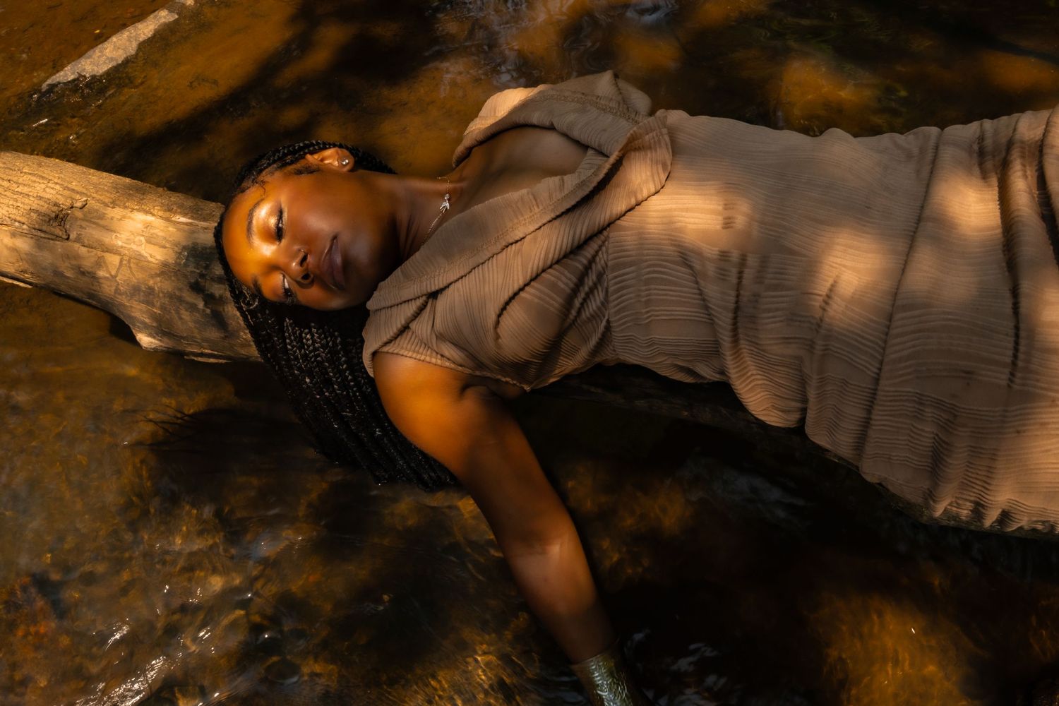 Dramatic nature portrait with soft lighting and flowing fabric creating ethereal woodland scene.
