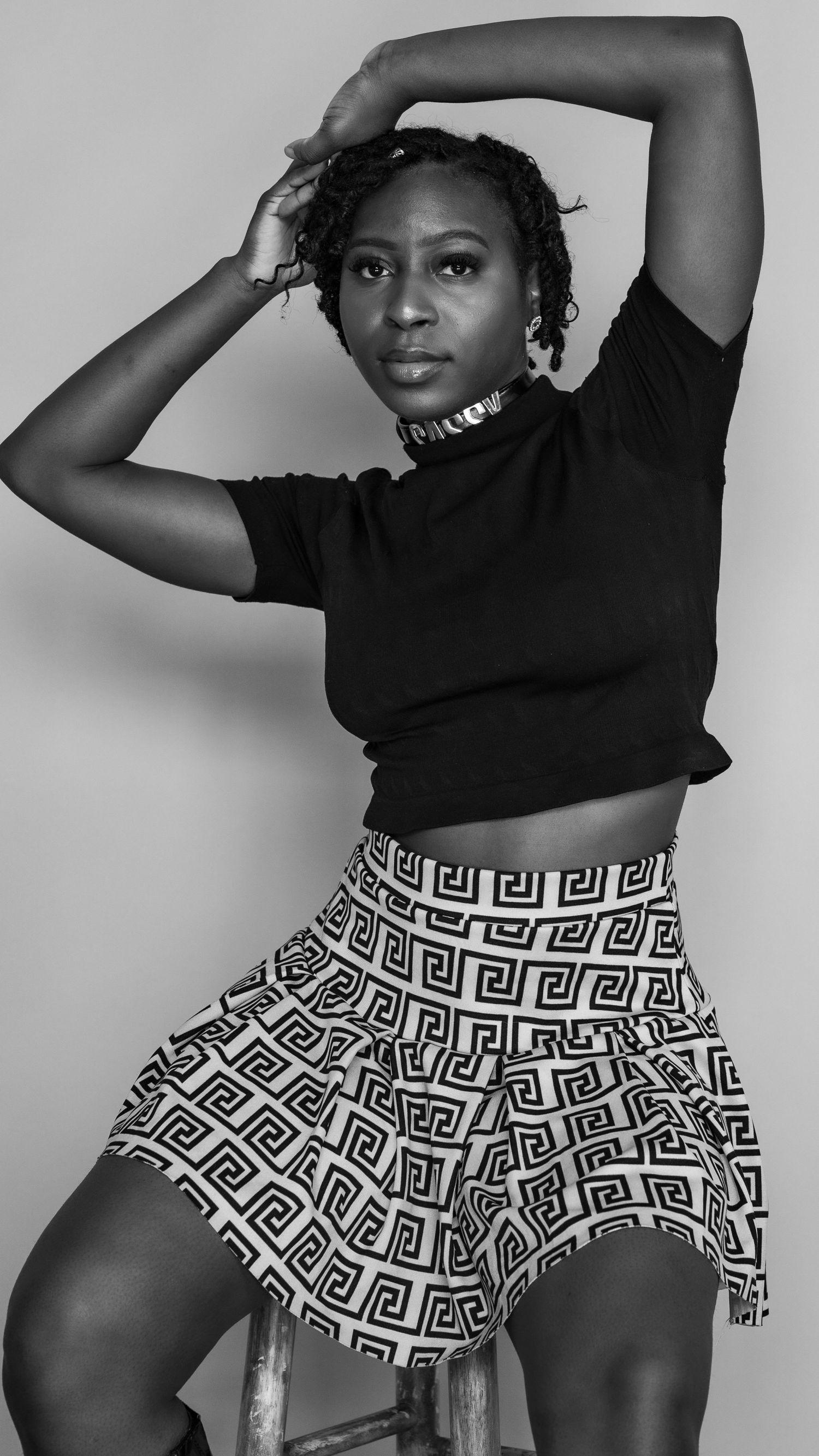 Black and white portrait showing modern dance pose in geometric print skirt.