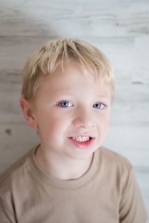 A series of close-up photos showing a young child in a beige shirt making playful expressions against a light background.