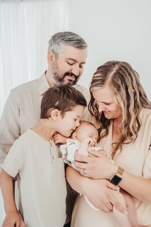 Family of three sharing intimate moments together in a series of tender poses against a white background.